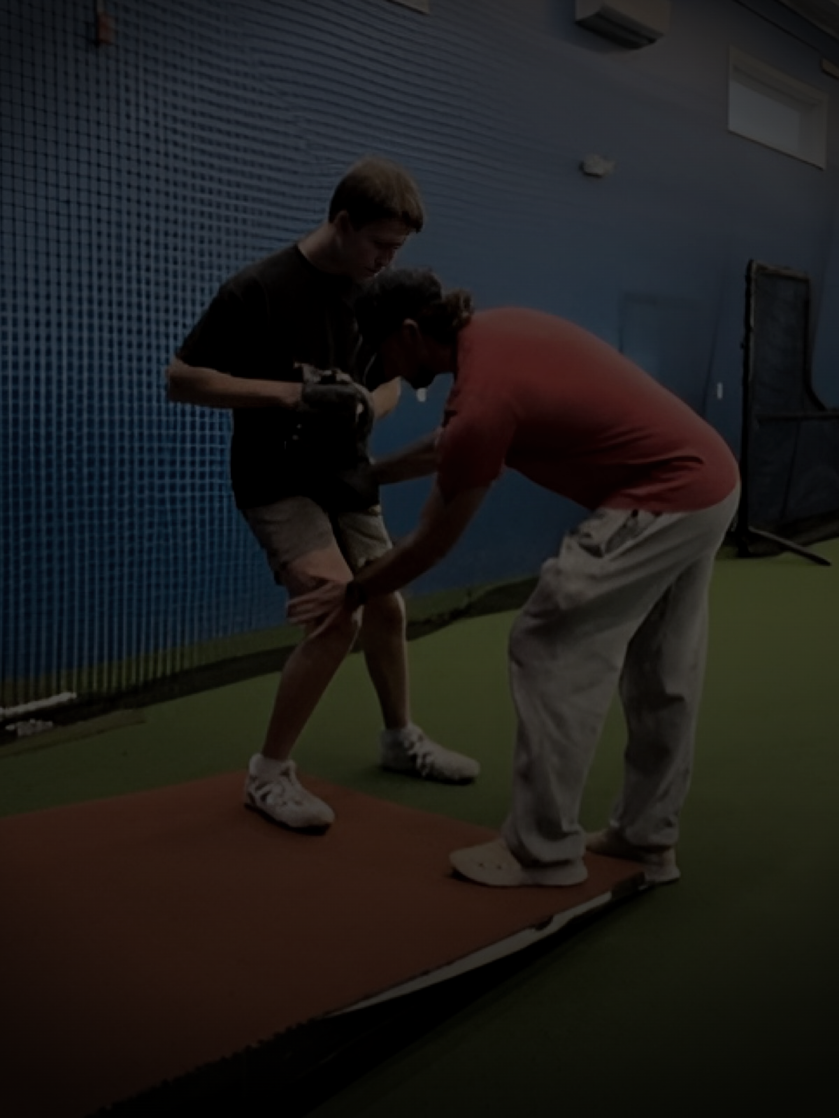 Coach CJ coaching an athlete in the cage