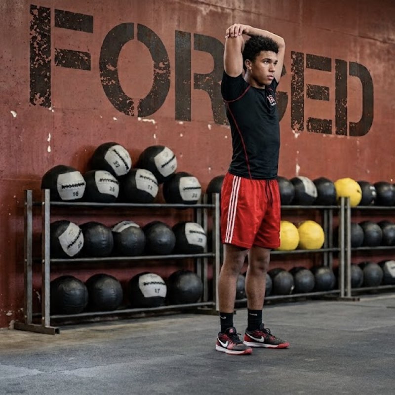 Athlete moving through an overhead mobility stretch in the training facility